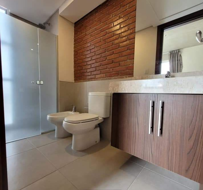 Baño con pared de ladrillo visto pulido