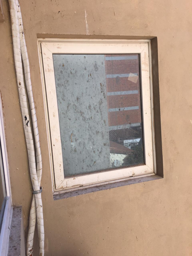 Ventana externa manchada por polvo y salpicaduras de obra