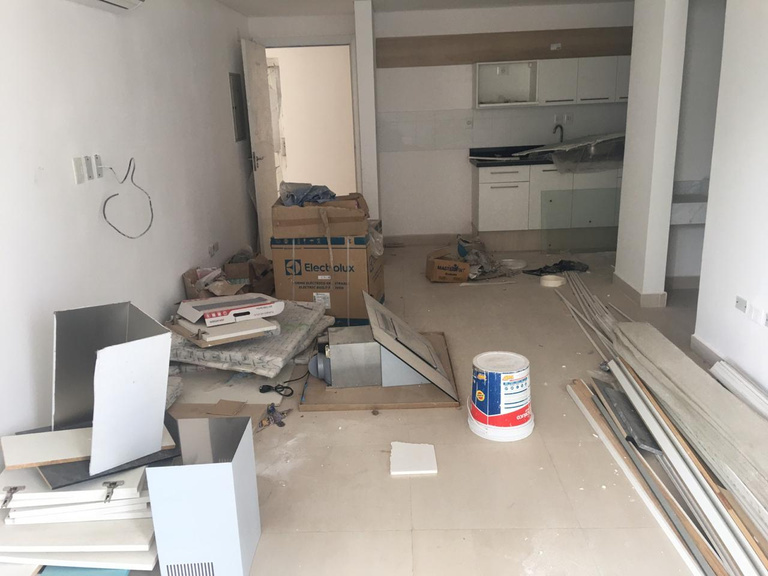 Departamento en obra con cajas, restos y polvo
